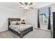 A bright bedroom with a fan and big window. Features carpet and light gray colored walls at 22229 Storybook Cabin Way, Land O Lakes, FL 34637
