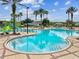 Inviting community pool with clear water, lounge chairs, and lush landscaping for relaxation at 22229 Storybook Cabin Way, Land O Lakes, FL 34637