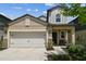 Beautiful home featuring a two-car garage, stone accents, and a welcoming front porch at 22229 Storybook Cabin Way, Land O Lakes, FL 34637
