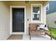 Close-up of the front door with a bench, a window, and elegant detailing at 22229 Storybook Cabin Way, Land O Lakes, FL 34637