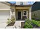 Inviting covered front porch with bench seating and manicured flower beds at 22229 Storybook Cabin Way, Land O Lakes, FL 34637
