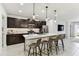 Modern kitchen with dark cabinets, a waterfall island, stainless steel appliances, and sleek pendant lighting at 22229 Storybook Cabin Way, Land O Lakes, FL 34637