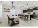 Open-concept kitchen and dining area with stainless steel appliances, dark cabinets, and a stylish marble waterfall island at 22229 Storybook Cabin Way, Land O Lakes, FL 34637