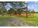 Community playground featuring covered play structures, swings, and benches for outdoor enjoyment at 22229 Storybook Cabin Way, Land O Lakes, FL 34637