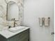 Stylish powder room featuring modern vanity, unique tiling, and gold fixtures at 22229 Storybook Cabin Way, Land O Lakes, FL 34637