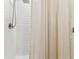Modern bathroom shower featuring white subway tile, rainfall shower head, and neutral-toned curtain at 22229 Storybook Cabin Way, Land O Lakes, FL 34637