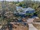 Aerial view of a home with mature trees and lush landscaping at 223 Lime S Cir, Dunedin, FL 34698