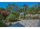 Lush backyard featuring a charming shed, potted plants, brick pavers, and well-manicured landscaping at 223 Lime S Cir, Dunedin, FL 34698