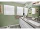 Bright bathroom with dual sinks, gray countertops, and tiled floors at 223 Lime S Cir, Dunedin, FL 34698