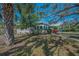 Charming home with light grey exterior, lush landscaping, and mature trees at 223 Lime S Cir, Dunedin, FL 34698