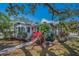 Charming home features mature landscaping, a pink front door, and light grey paint at 223 Lime S Cir, Dunedin, FL 34698