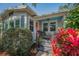 Cozy front porch featuring address, seating, and colorful landscaping at 223 Lime S Cir, Dunedin, FL 34698