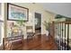 Upstairs hallway with hardwood floors and view into the bedroom at 223 Lime S Cir, Dunedin, FL 34698