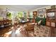 Comfortable living room with plants, vintage furniture, and sun-drenched windows at 223 Lime S Cir, Dunedin, FL 34698
