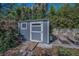Backyard shed with ramp access, surrounded by lush landscaping and a seating area at 223 Lime S Cir, Dunedin, FL 34698