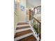 Elegant staircase featuring hardwood steps, white risers, and decorative railing at 223 Lime S Cir, Dunedin, FL 34698