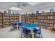 Spacious library with rows of books and round tables with chairs at 2489 Oakleaf Ln # 21C, Clearwater, FL 33763