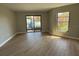 Spacious living room featuring modern wood floors, natural light, and a sliding glass door at 2571 Cyprus Dr # 1-102, Palm Harbor, FL 34684