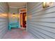 Inviting front porch with brick flooring, a quaint turquoise bench, and a vibrant red front door at 2837 Bayshore Trails Dr, Tampa, FL 33611