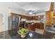 Traditional kitchen featuring rich wood cabinetry, stainless steel appliances, and black countertops with dining space at 301 71St S St, St Petersburg, FL 33707