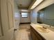 Bathroom with tiled tub and shower, white vanity with a sink and ample lighting at 3257 Bluestone Ave, Spring Hill, FL 34609