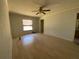 Spacious bedroom featuring wood floors, a ceiling fan, and natural light at 3257 Bluestone Ave, Spring Hill, FL 34609