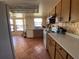 View of a kitchen with tile floors, white appliances, and wood cabinets at 3257 Bluestone Ave, Spring Hill, FL 34609