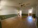 Spacious living room with hardwood floors, a ceiling fan, neutral colors, and baseboards throughout at 3257 Bluestone Ave, Spring Hill, FL 34609