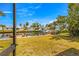 Backyard with boat dock on canal with grass, and palm trees, offering serene outdoor living at 4061 13Th Ne Ln, St Petersburg, FL 33703