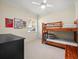 Bright bedroom featuring a wooden bunk bed and a black dresser underneath a ceiling fan at 428 Pine Bluff Dr, Lutz, FL 33549