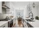 Bright kitchen featuring white cabinetry, stainless steel appliances, and an open dining area at 4515 W North A St # 4, Tampa, FL 33609