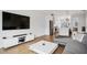Open-concept living room with hardwood floors, a modern entertainment center, and a view into the kitchen at 4515 W North A St # 4, Tampa, FL 33609