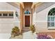 Inviting front entrance with a charming red door and landscaped surroundings at 4517 Havelocke Dr, Land O Lakes, FL 34638
