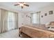 Bright bedroom with carpet, two windows with curtains, ceiling fan and queen sized bed at 4555 Debbie Ln, Lutz, FL 33559