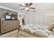Bedroom with a ceiling fan, a wooden dresser with television, and closet doors at 4555 Debbie Ln, Lutz, FL 33559
