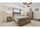 Cozy bedroom featuring a large wooden bed frame, a ceiling fan, and complementing nightstands and dresser at 4555 Debbie Ln, Lutz, FL 33559