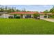 Charming single-story home features a vibrant red tile roof, lush green lawn, and mature landscaping at 4555 Debbie Ln, Lutz, FL 33559