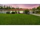 Inviting single-story home boasts a red tile roof, a well-manicured lawn, and a picturesque sunset backdrop at 4555 Debbie Ln, Lutz, FL 33559