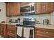Well-equipped kitchen featuring stainless steel appliances, dark wood cabinetry, and a stylish backsplash at 4555 Debbie Ln, Lutz, FL 33559