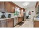 Well-lit kitchen featuring wood cabinets, stainless steel appliances, tile backsplash, and tile flooring at 4555 Debbie Ln, Lutz, FL 33559