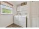 The laundry room contains a washer and dryer with white cabinets at 4555 Debbie Ln, Lutz, FL 33559