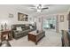 Comfortable living room featuring a plush sofa, wood coffee table, ceiling fan, and access to outdoor patio at 4555 Debbie Ln, Lutz, FL 33559
