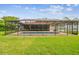 Backyard screened pool with ample green space, offering a perfect setting for relaxation at 4555 Debbie Ln, Lutz, FL 33559