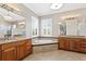 Bright bathroom boasts a soaking tub with tile surround, dual vanities with granite countertops, and a calming ambiance at 47 Martinique Ave, Tampa, FL 33606