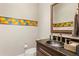Powder room featuring a dark vanity, hammered bowl sink, and colorful decorative tile accent at 47 Martinique Ave, Tampa, FL 33606