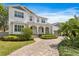 Charming two-story home with a brick driveway, arched porch, and well-maintained front yard with lush greenery at 47 Martinique Ave, Tampa, FL 33606