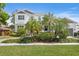 Inviting two-story house with a lush green lawn and beautiful tropical plants in the front yard at 47 Martinique Ave, Tampa, FL 33606