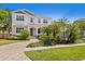 Elegant two-story house featuring a beautiful white exterior, arched porch, and meticulously landscaped front yard at 47 Martinique Ave, Tampa, FL 33606
