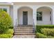 Close-up of the front door of the home, showing stone steps, gray door, and well-manicured landscaping at 47 Martinique Ave, Tampa, FL 33606