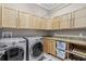 Bright laundry room with side-by-side washer and dryer and lots of cabinet storage at 47 Martinique Ave, Tampa, FL 33606